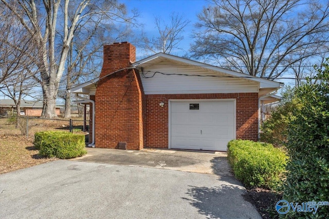 view of property exterior with a garage, concrete driveway, brick siding, and a chimney