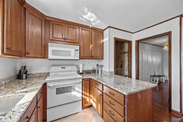 kitchen featuring light stone counters, white appliances, a textured ceiling, and light tile patterned floors