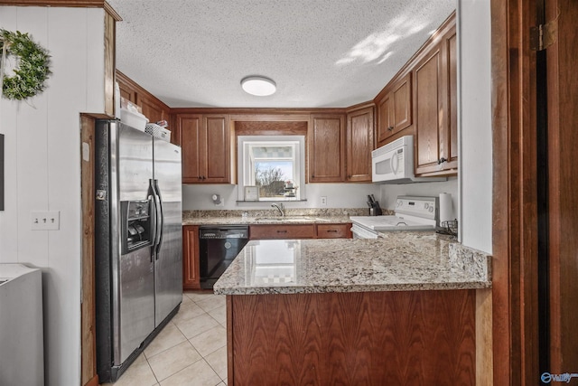 kitchen with sink, light stone counters, light tile patterned floors, kitchen peninsula, and white appliances