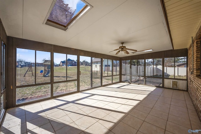 unfurnished sunroom featuring ceiling fan and a skylight