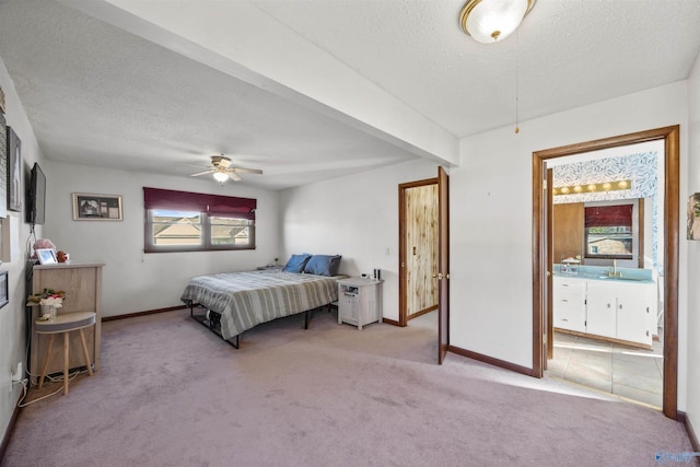 carpeted bedroom with ceiling fan, beam ceiling, sink, and a textured ceiling