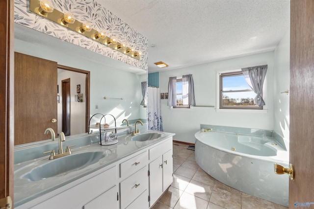 bathroom with vanity, a bathtub, tile patterned floors, and a textured ceiling