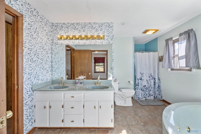 bathroom featuring walk in shower, vanity, toilet, and a textured ceiling