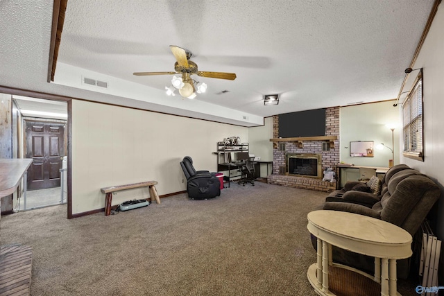 carpeted living room with ceiling fan, a fireplace, and a textured ceiling