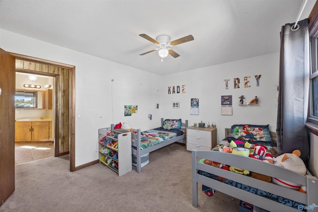 bedroom featuring light carpet, connected bathroom, and ceiling fan