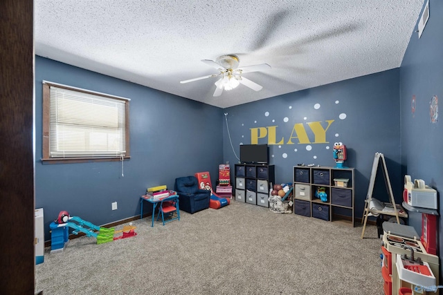 rec room with a textured ceiling, ceiling fan, and carpet