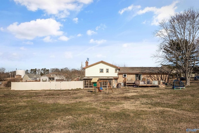 back of house with a wooden deck and a yard