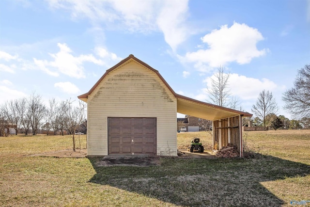 exterior space featuring an outbuilding, a garage, and a yard