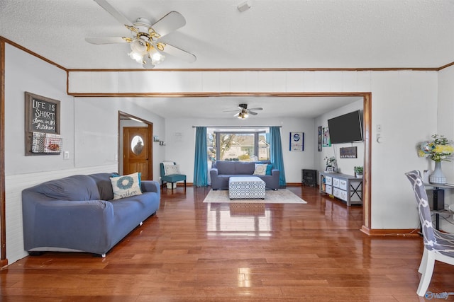 living room featuring ceiling fan, hardwood / wood-style floors, and a textured ceiling