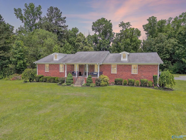 208 Burgess Ave, Rainsville, AL 35986 - view of front of home featuring a lawn, brick siding, a porch, and view of scattered trees