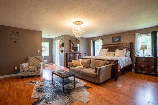 208 Burgess Ave, Rainsville, AL 35986 - bedroom featuring multiple windows, light wood-style floors, a textured ceiling, and a chandelier