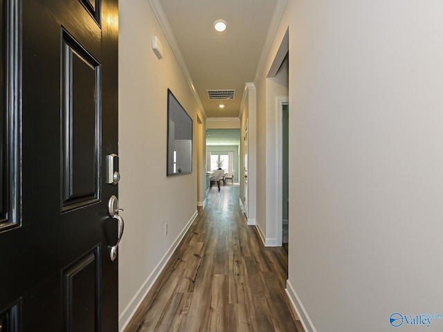 hall featuring crown molding, dark wood-style floors, baseboards, and recessed lighting