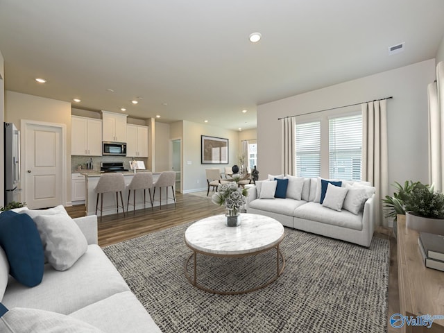 living room featuring light wood-style floors, recessed lighting, and baseboards