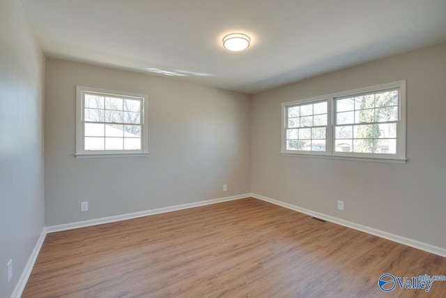 empty room with baseboards and wood finished floors