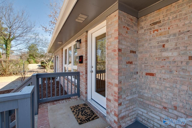 view of exterior entry with brick siding