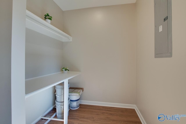 laundry area featuring wood finished floors, electric panel, and baseboards