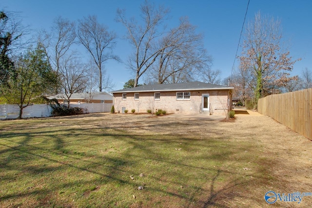 rear view of property with a fenced backyard and a yard