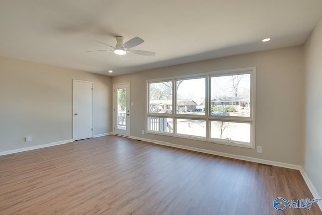 empty room with a ceiling fan, baseboards, and wood finished floors