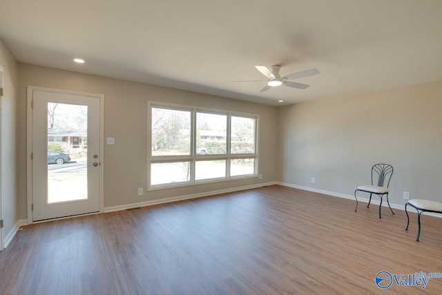 unfurnished room with a wealth of natural light, baseboards, and wood finished floors