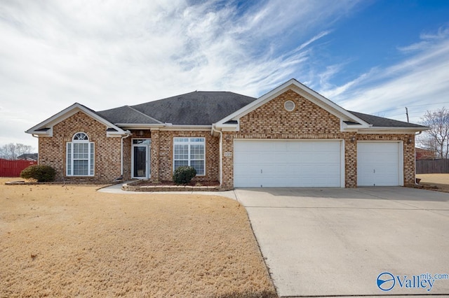 ranch-style home featuring driveway, brick siding, an attached garage, and fence