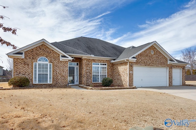 ranch-style house with an attached garage, driveway, a shingled roof, and brick siding