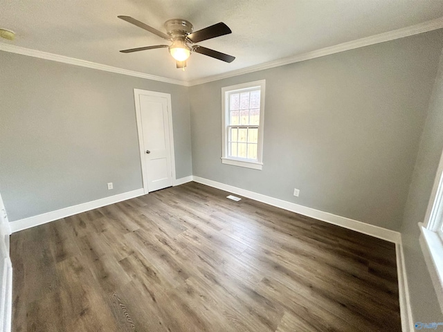 spare room featuring crown molding, a ceiling fan, dark wood-style flooring, and baseboards