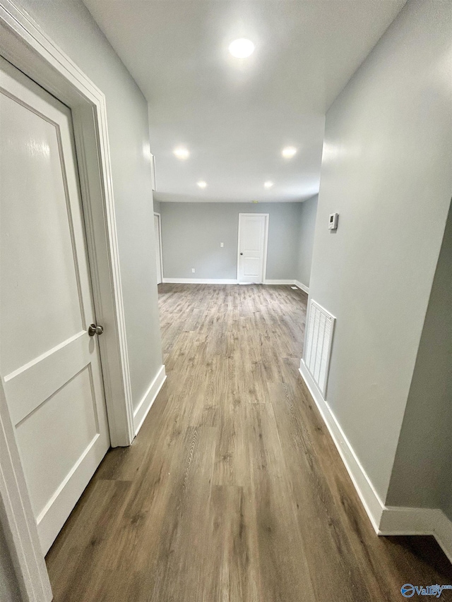 corridor featuring baseboards, recessed lighting, wood finished floors, and visible vents