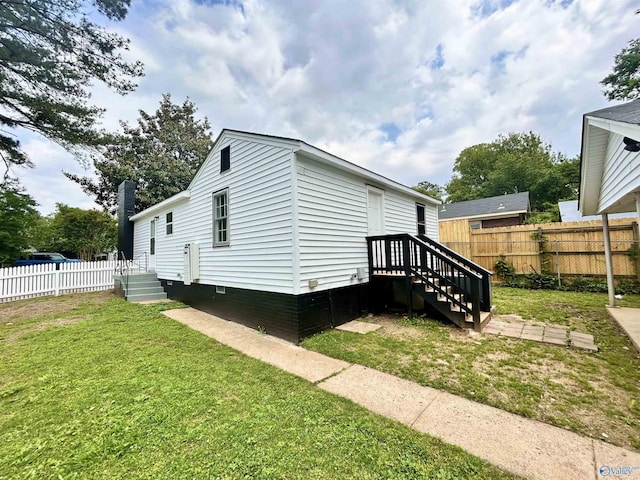 view of side of property with a yard, crawl space, and fence