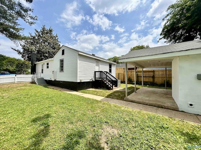 view of side of home featuring fence, a patio, and a yard