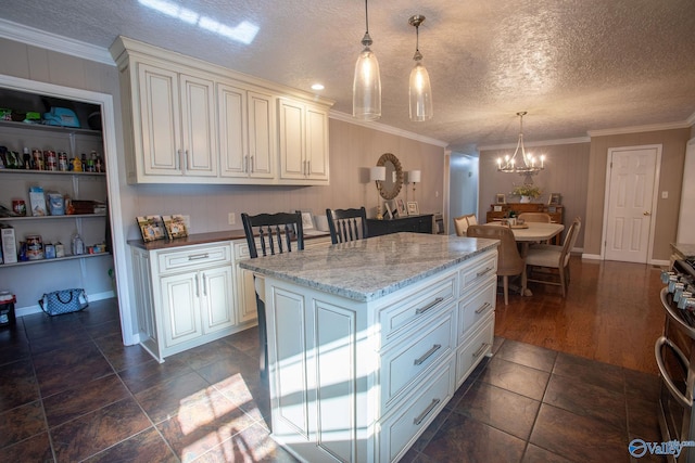 kitchen featuring hanging light fixtures, light stone counters, ornamental molding, a textured ceiling, and a kitchen island