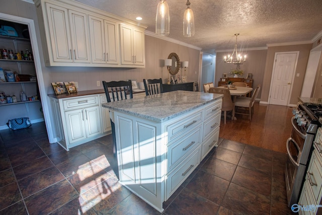 kitchen featuring crown molding, hanging light fixtures, a center island, stainless steel gas range oven, and a textured ceiling