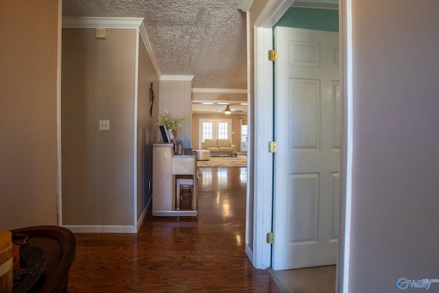 hallway with crown molding, dark wood-type flooring, and a textured ceiling