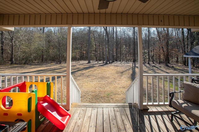 wooden deck with a playground and ceiling fan