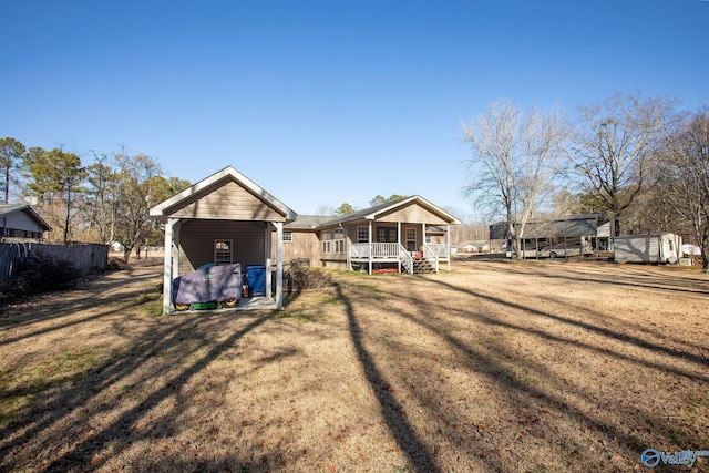 rear view of house with a lawn and covered porch