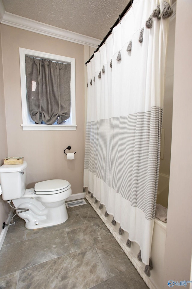 bathroom with ornamental molding, toilet, shower / tub combo, and a textured ceiling