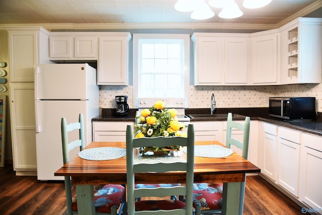 kitchen with white refrigerator, sink, ornamental molding, dark hardwood / wood-style flooring, and white cabinetry