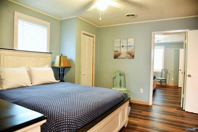 bedroom featuring ceiling fan, a closet, dark wood-type flooring, and ornamental molding