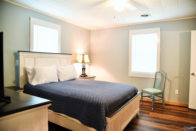 bedroom with dark hardwood / wood-style flooring, ceiling fan, and crown molding