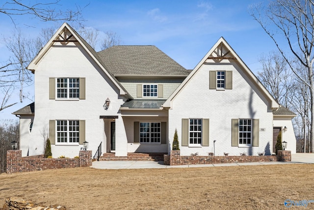 58 Watson Grande Way, Owens Cross Roads, AL 35763 - rear view of property featuring brick siding, a lawn, roof with shingles, and a standing seam roof