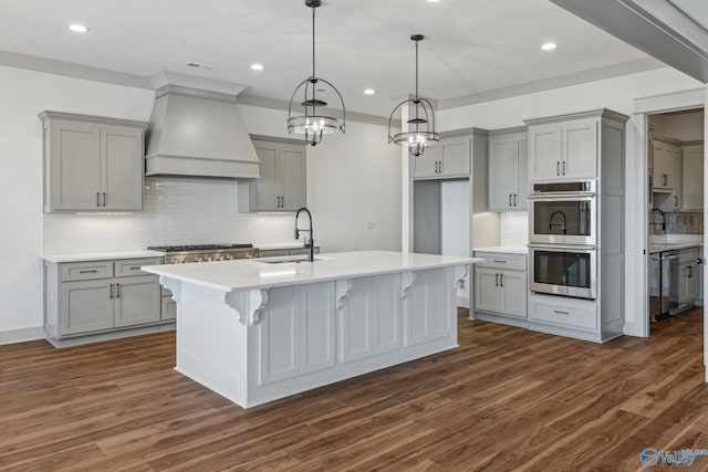 kitchen featuring sink, gray cabinets, appliances with stainless steel finishes, and premium range hood