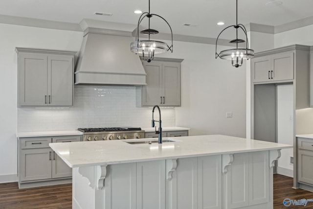 kitchen with custom exhaust hood, sink, gray cabinetry, and light stone counters