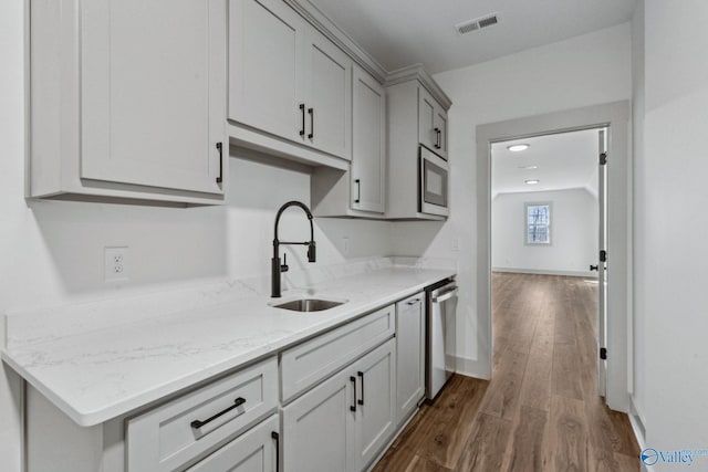 kitchen featuring sink, dark wood-type flooring, appliances with stainless steel finishes, gray cabinetry, and light stone counters