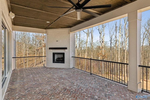 view of patio featuring a fireplace and ceiling fan