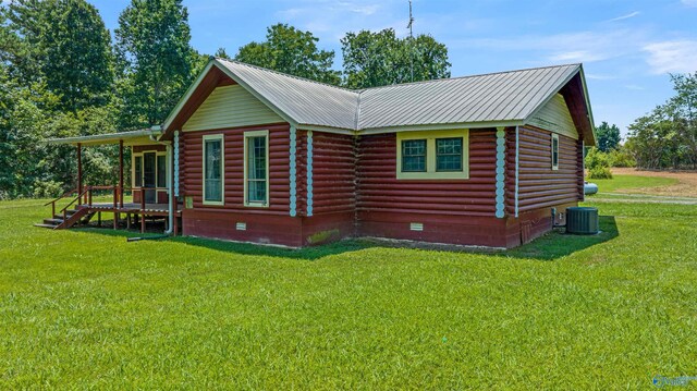 rear view of property with cooling unit and a lawn