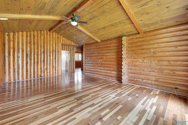 spare room featuring wood ceiling, hardwood / wood-style flooring, vaulted ceiling with beams, and rustic walls