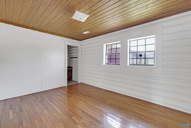 empty room featuring wooden ceiling and hardwood / wood-style floors