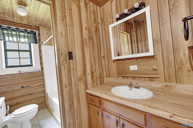 full bathroom featuring tile patterned flooring, wooden walls, toilet, vanity, and  shower combination