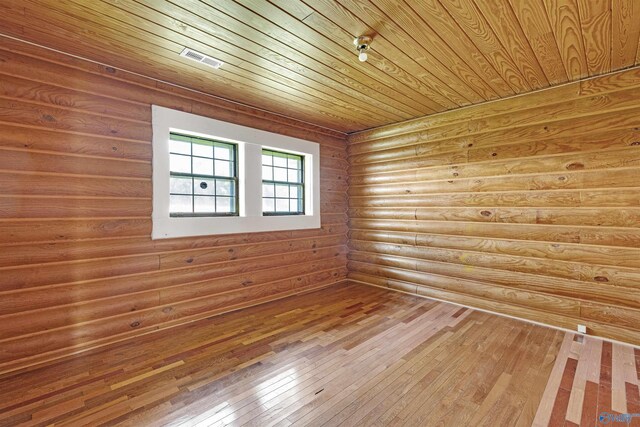 spare room featuring wooden ceiling, wood-type flooring, and rustic walls