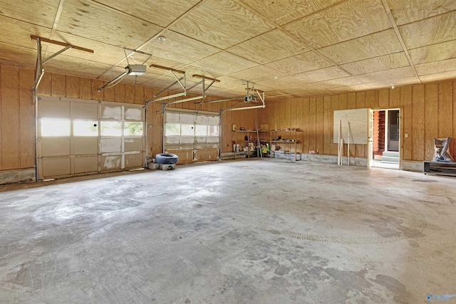 garage with a garage door opener and wooden walls