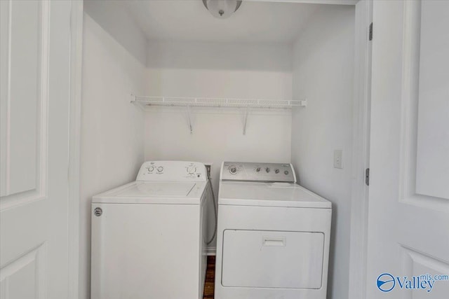 clothes washing area with washer and clothes dryer and laundry area